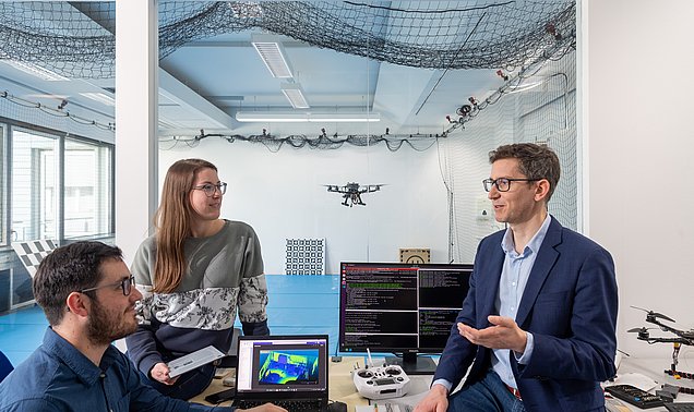 Forschende arbeiten in einem Labor mit einer Drohne.